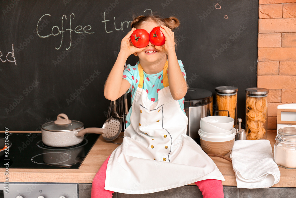 Little housewife cooking in kitchen