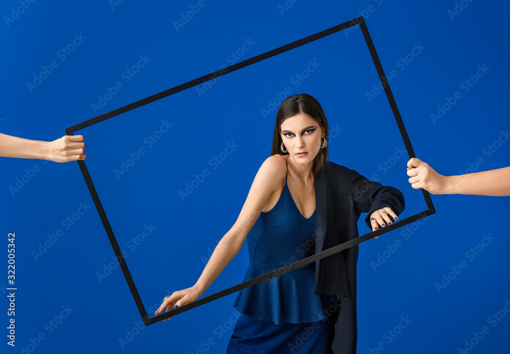 Portrait of fashionable young woman on blue background