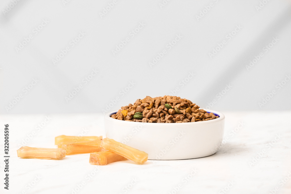 Bowl with dry pet food on table