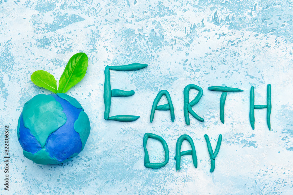 Planet and text EARTH DAY on color background