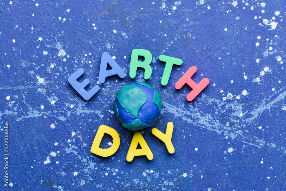 Planet and text EARTH DAY on color background