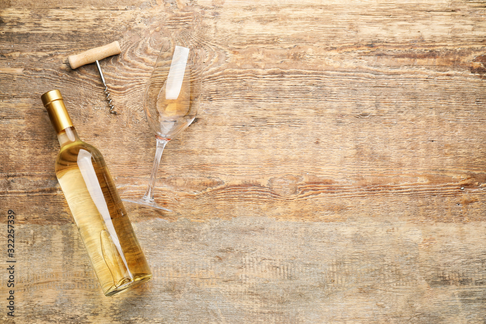 Glass and bottle of delicious wine on wooden background