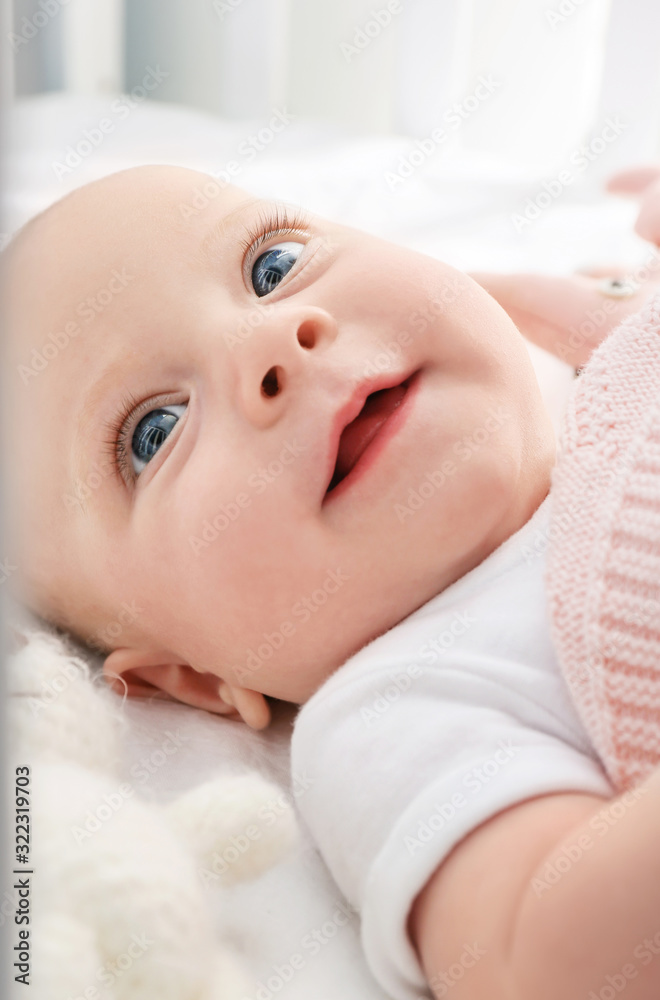 Portrait of cute little baby lying on bed, closeup