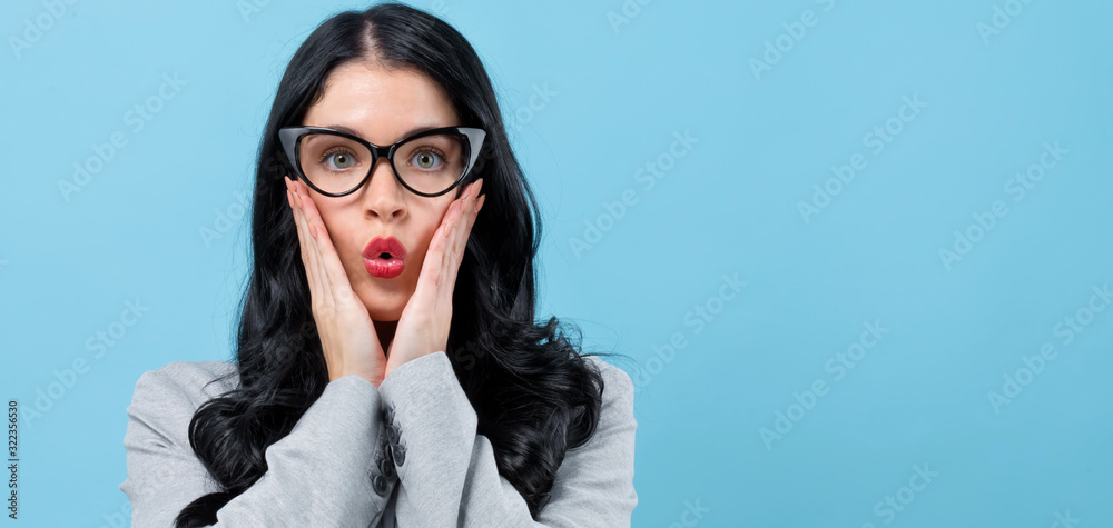 Surprised young woman posing on a blue background