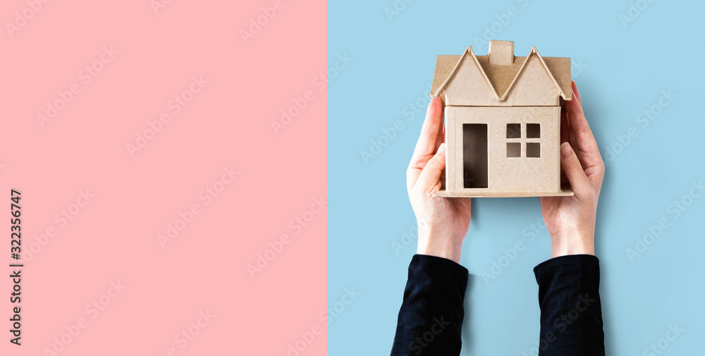 Woman holding a cardboard house overhead view