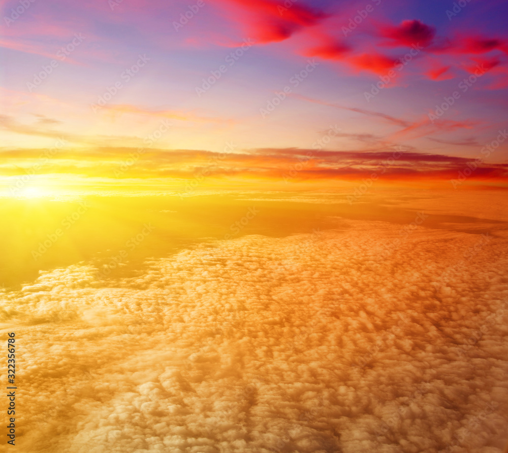 Sunrise above clouds from airplane