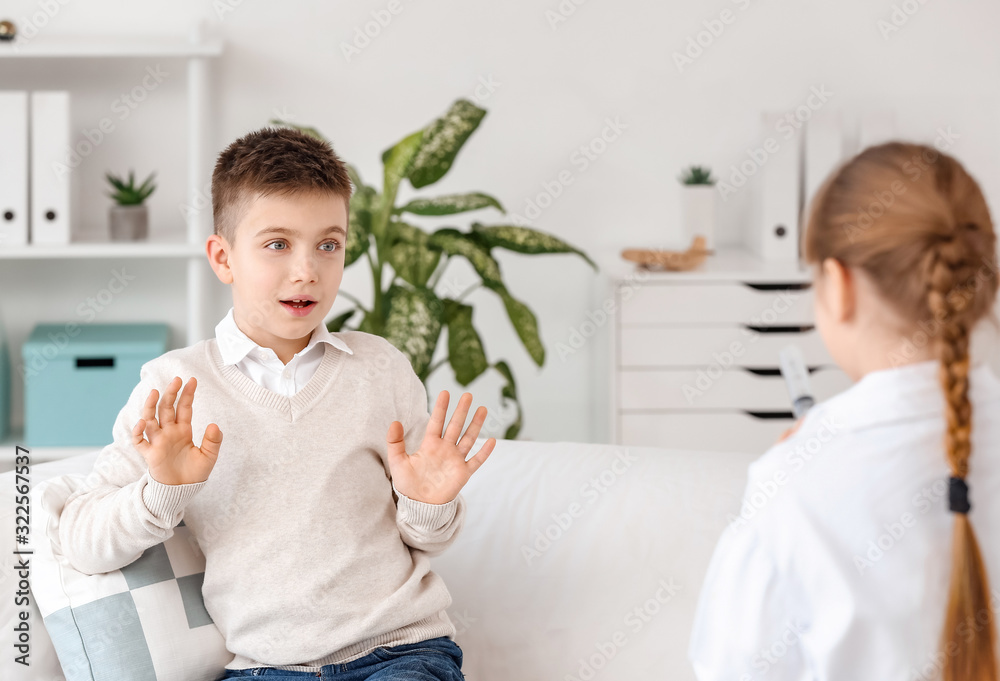 Cute little doctor working with scared patient in clinic