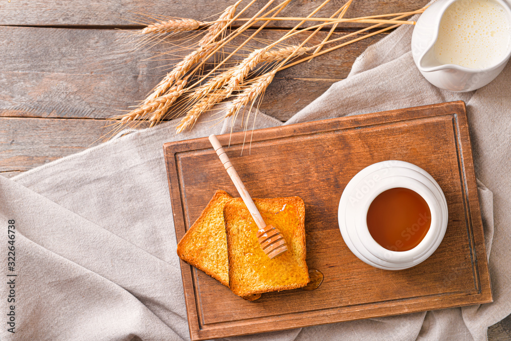 Sweet honey, milk and toasted bread on table