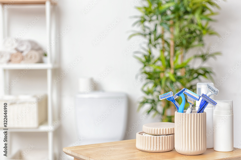 Razors for hair removal with cosmetics on table in bathroom