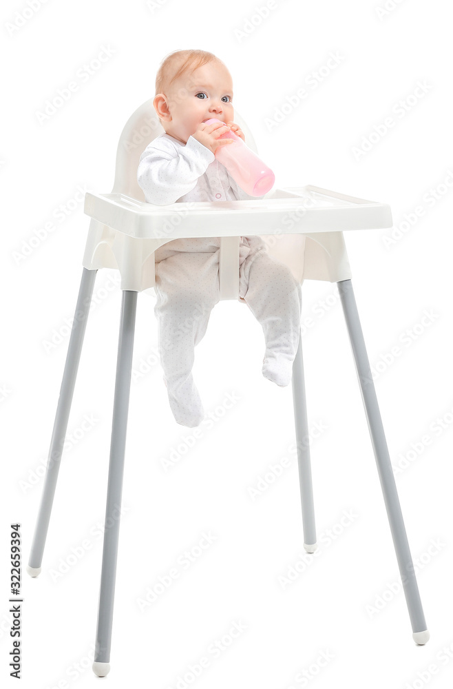 Baby with bottle of milk sitting in high-chair on white background