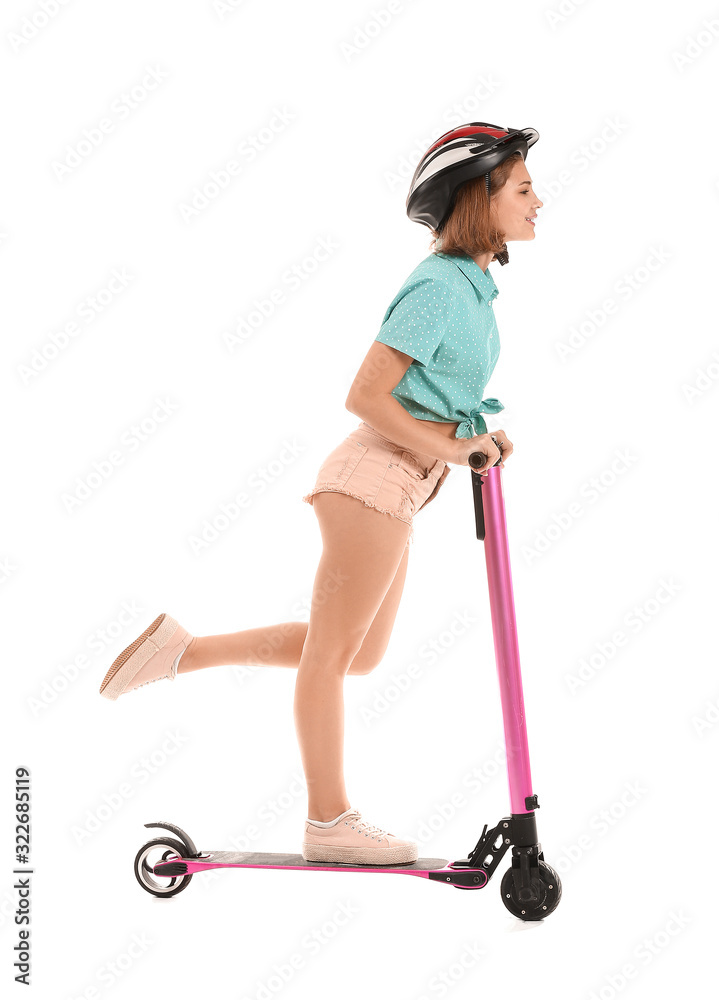 Teenage girl riding kick scooter on white background