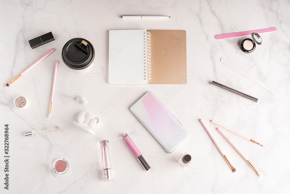 Feminine workspace in flat lay style with opend notepad, up-to-date smartphone mockup, coffee paper 