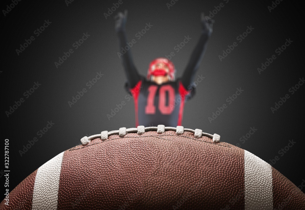 American football ball and football player on dark background