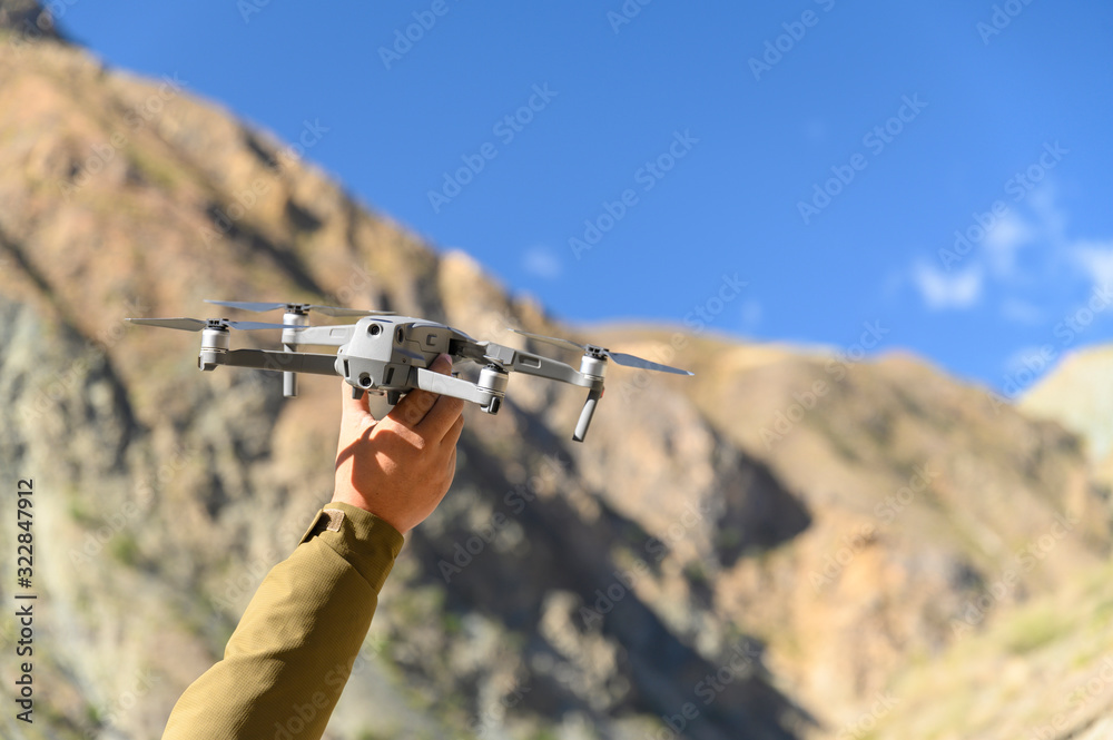 Man catching drone on hand ready for take off or landing in rural