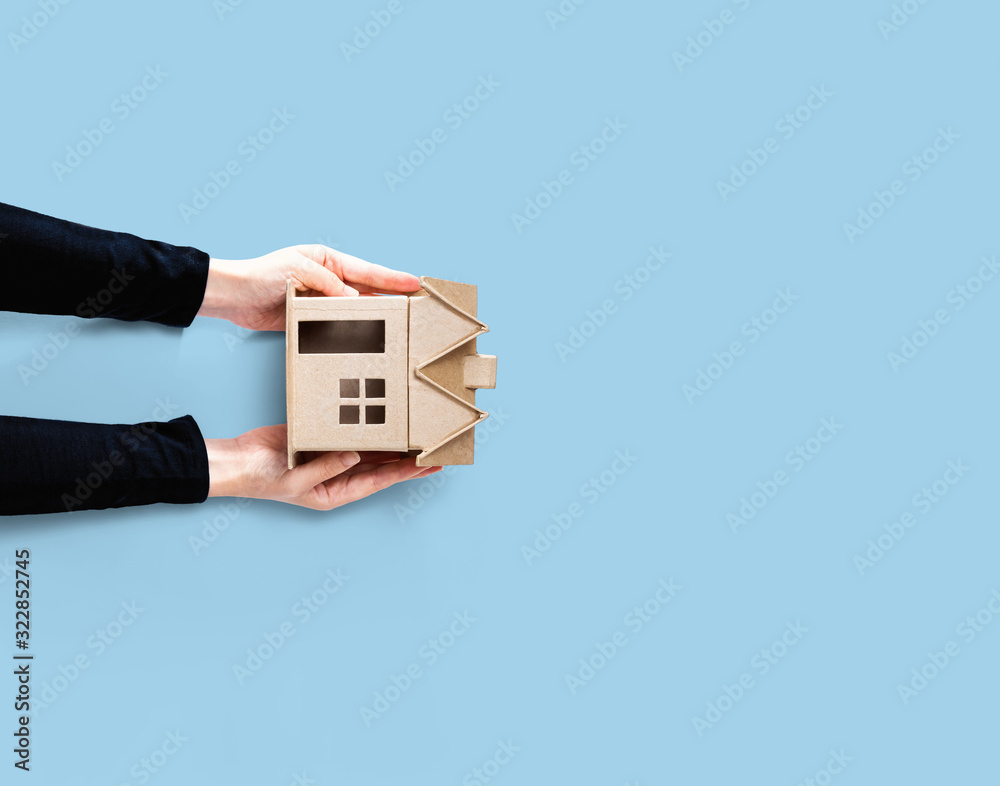 Woman holding a cardboard house overhead view