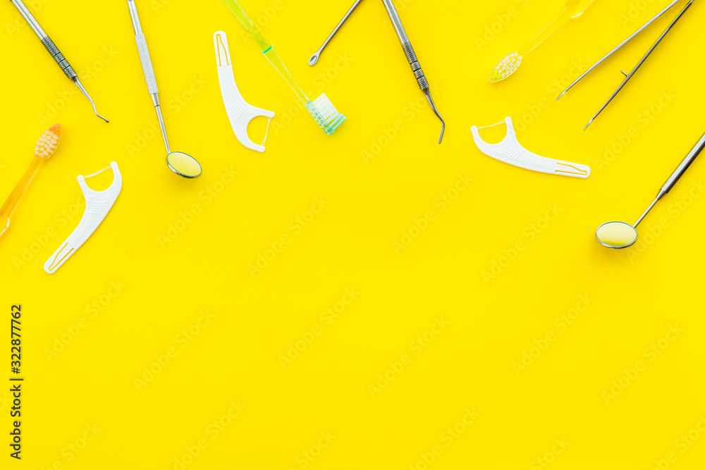 Dental care concept. Stomatological tools frame - with floss - on yellow background top-down frame s