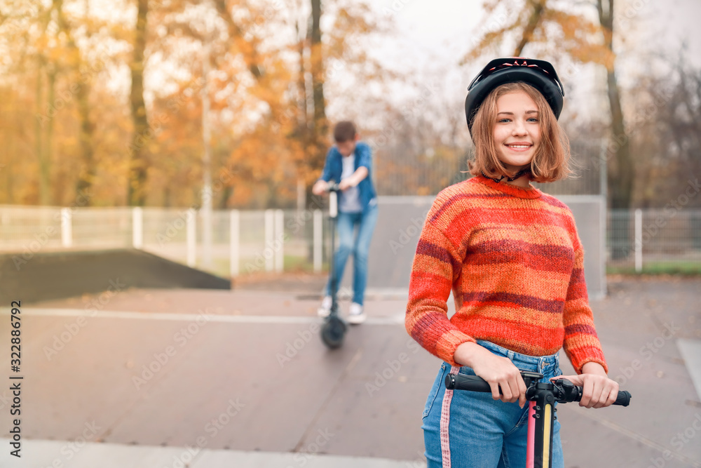 青少年女孩在滑冰公园骑脚踏滑板车