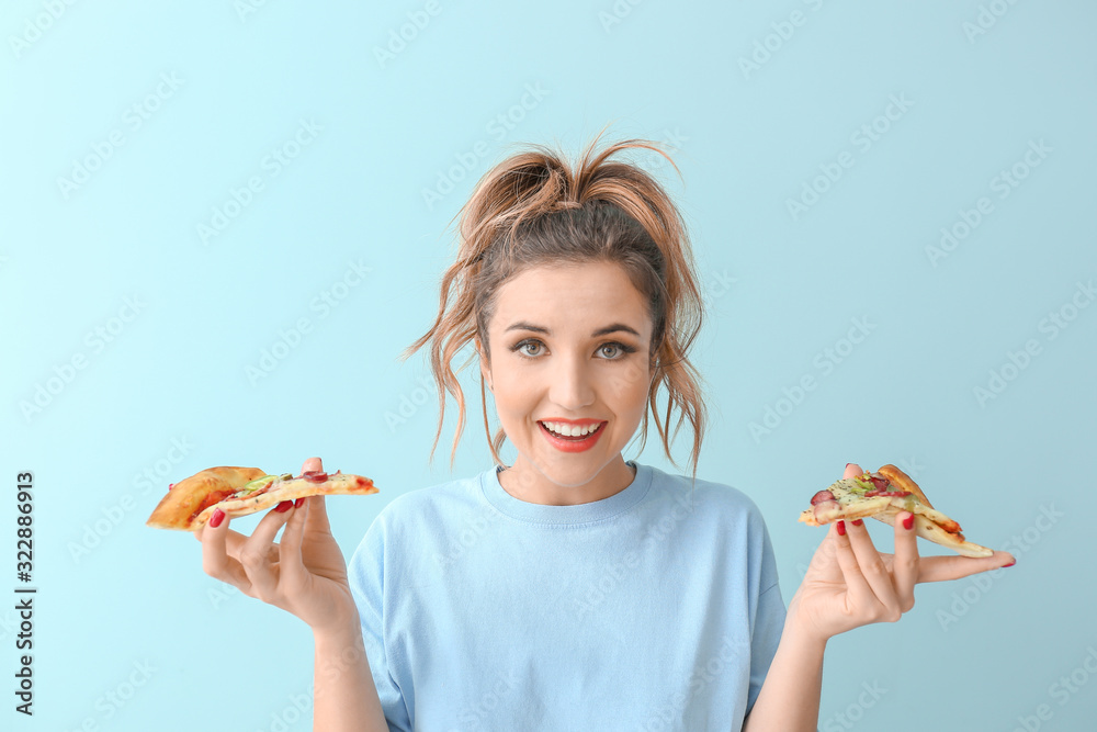 Portrait of beautiful young woman with pizza on color background