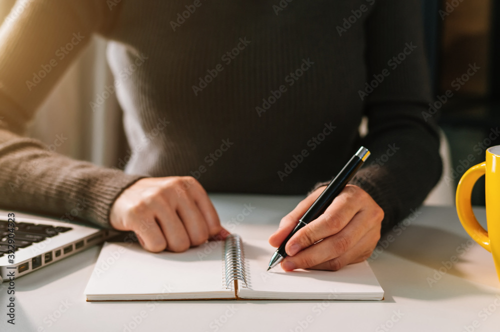 businessman hand working with new modern computer and writing on the notepad strategy diagram as con