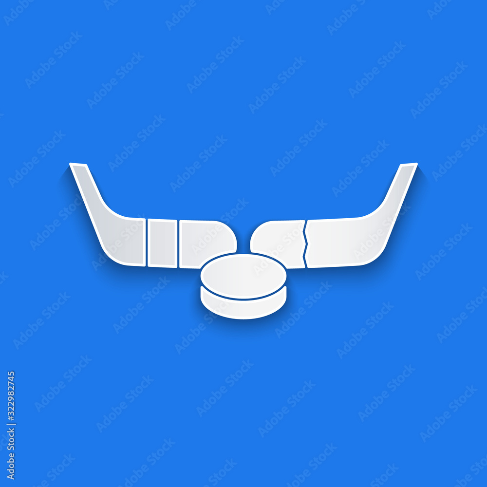 Paper cut Ice hockey sticks and puck icon isolated on blue background. Game start. Paper art style. 