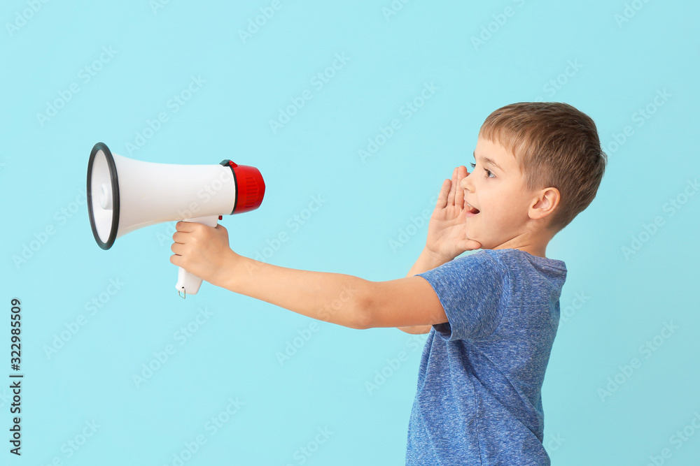 Cute little boy with megaphone on color background