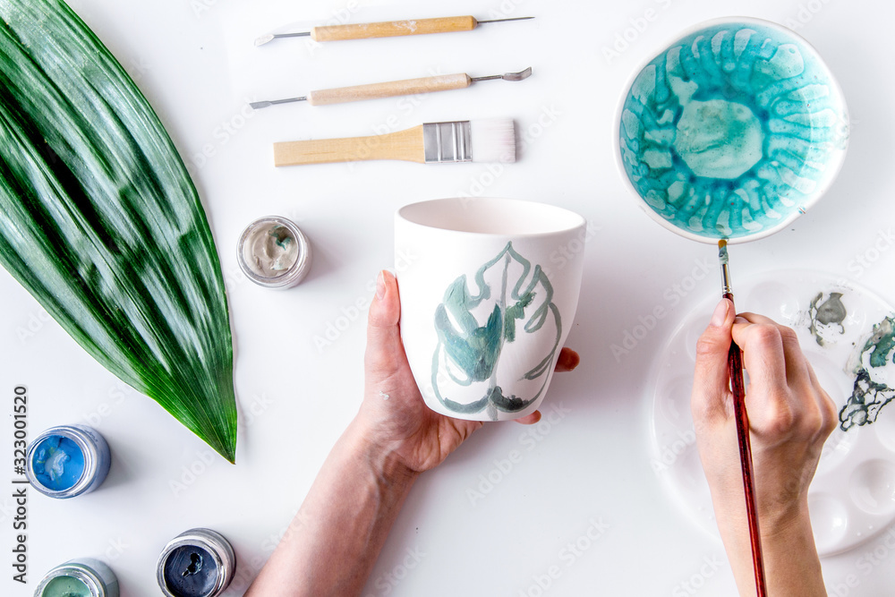 painted ceramic cup on white background top view