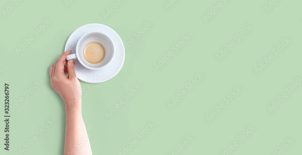 Female hand holding a tea cup overhead view - flat lay