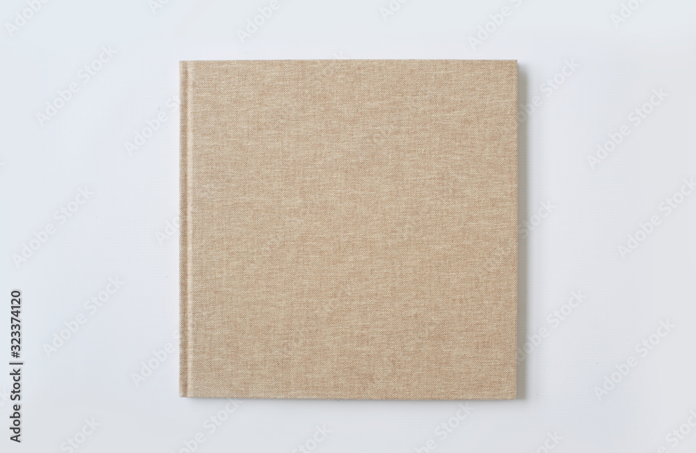  A large beige hardcover book is on the table