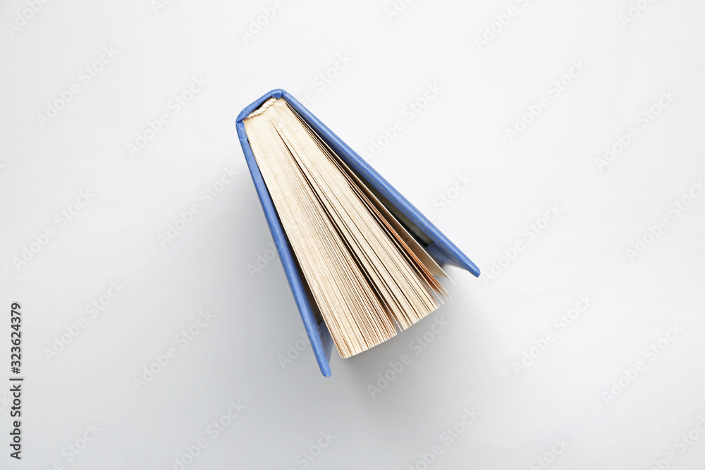 Book on light background, top view