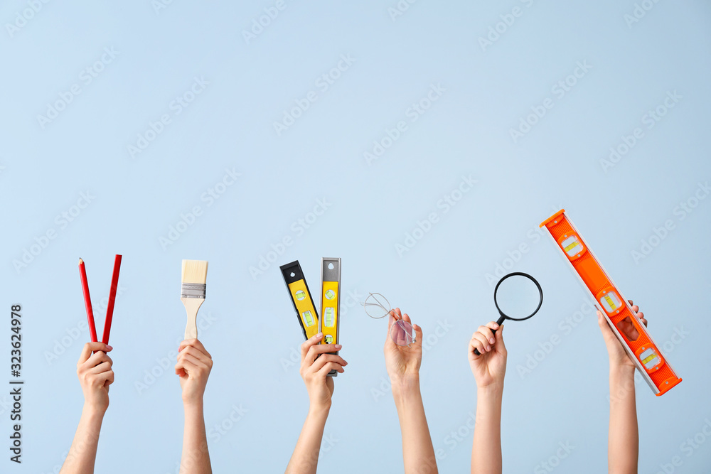 Many hands with architects supplies on color background