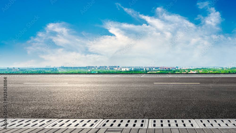 阳光明媚的上海，空旷的柏油公路和城市郊区的天际线。