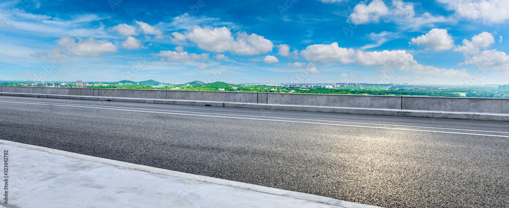 Wide asphalt highway and city suburb skyline on a sunny day in Shanghai,panoramic view.