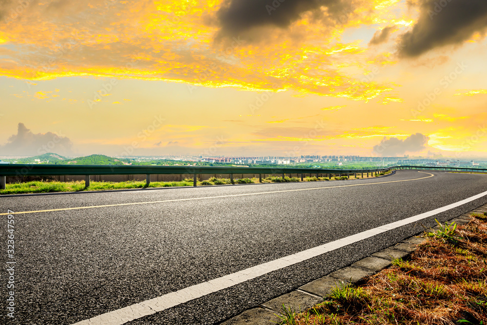 Empty asphalt highway and city suburb skyline in Shanghai at sunset.