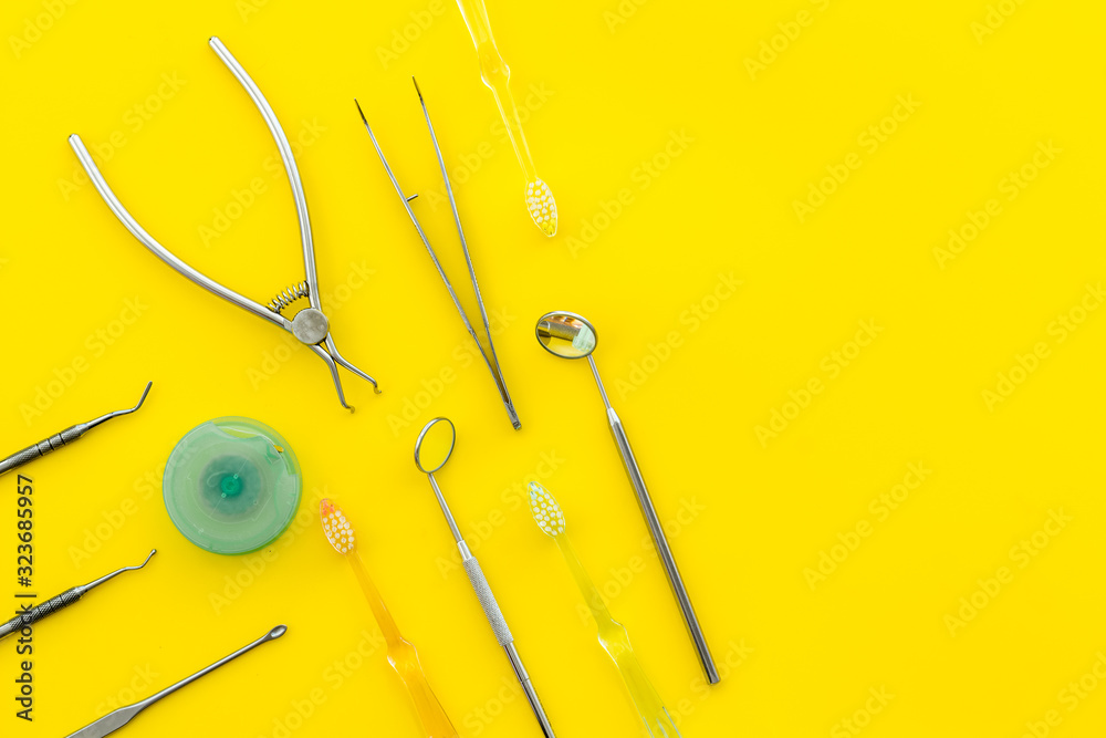 Dental care concept. Stomatological tools frame - with floss - on yellow background top-down frame c