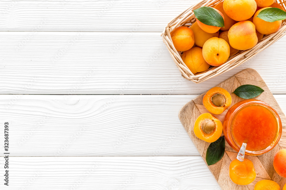 Healthy breakfast. Apricot jam in jar near fresh fruits on white wooden background top view frame co