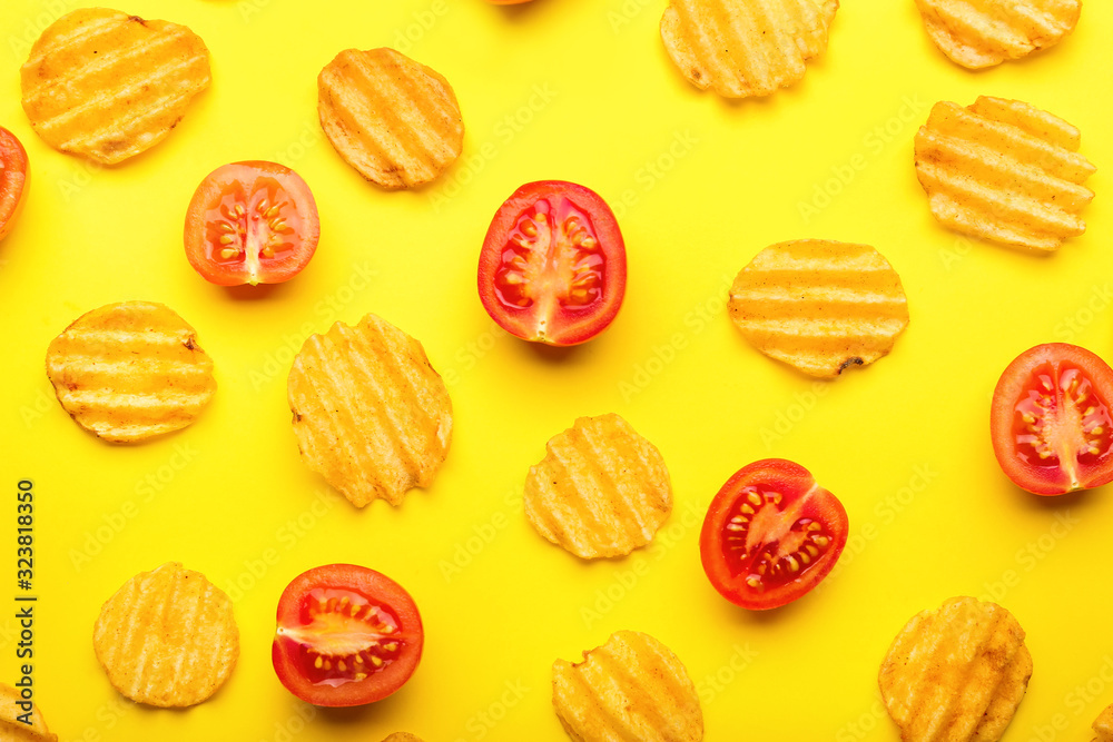 Tasty potato chips and tomato on color background