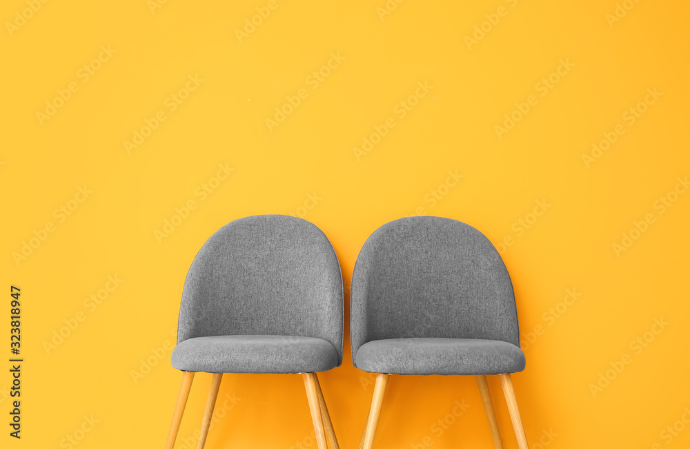 Chairs near color wall in room