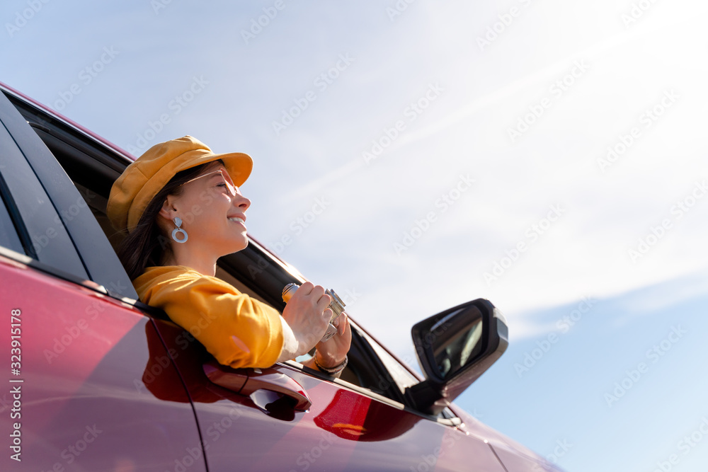 Happy woman in a red car