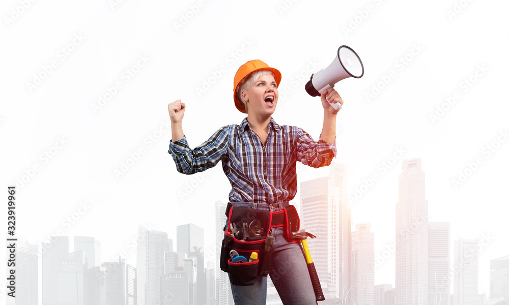 Expressive woman in helmet shouting into megaphone