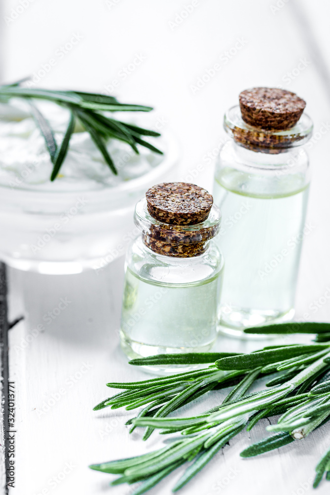 natural essential aroma oil with rosemary on wooden table background