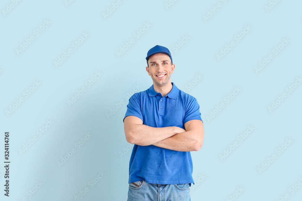 Handsome delivery man on color background