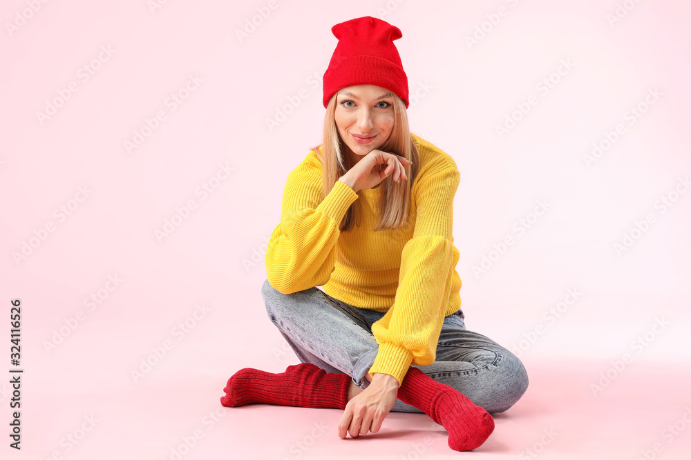 Young woman in warm sweater on color background