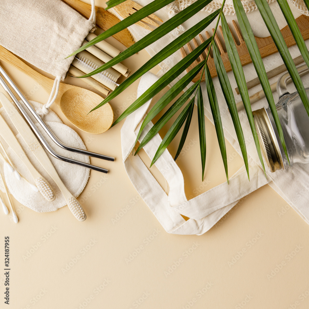 Cotton bag, bamboo cultery, glass jar, bamboo toothbrushes, hairbrush and straws on color background