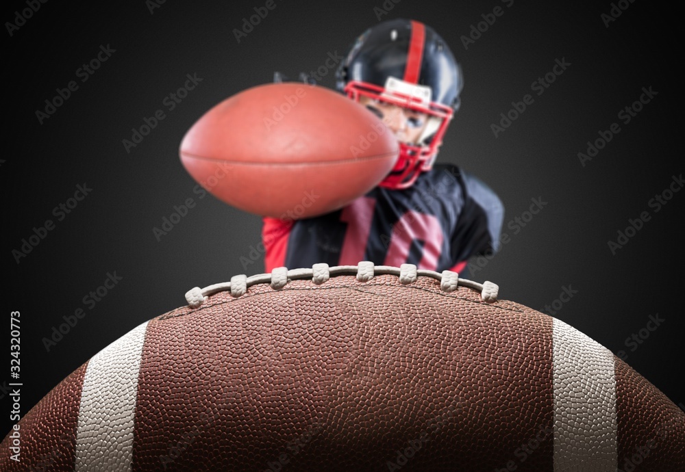 American football ball and football player on dark background