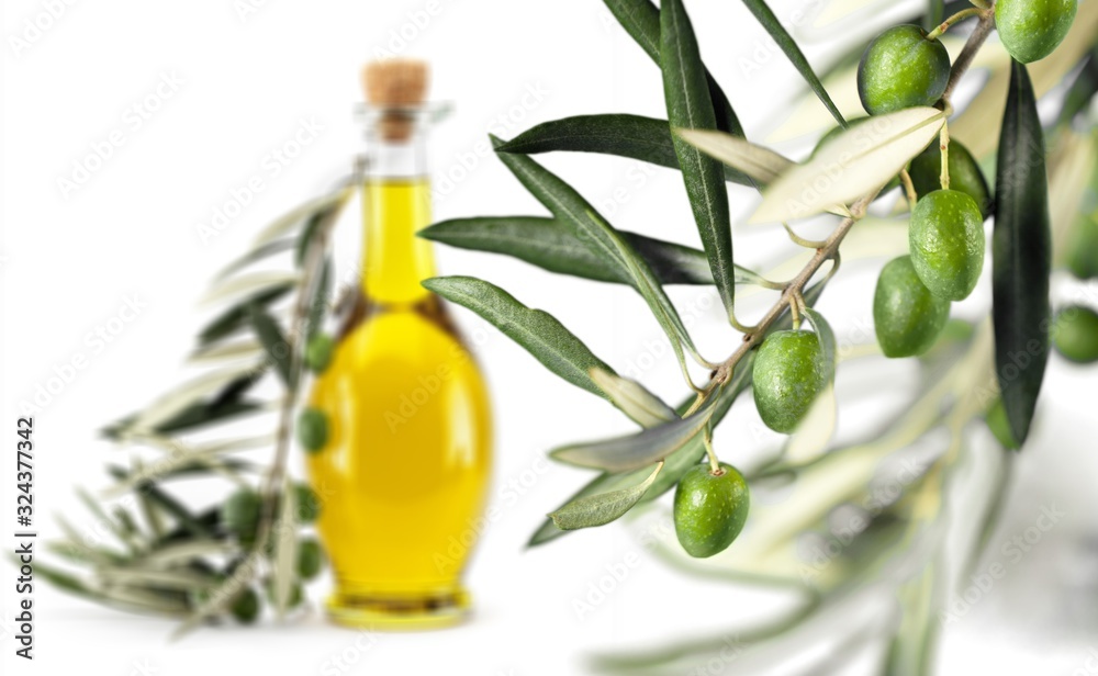 Glass bottle of olive oil with green olives