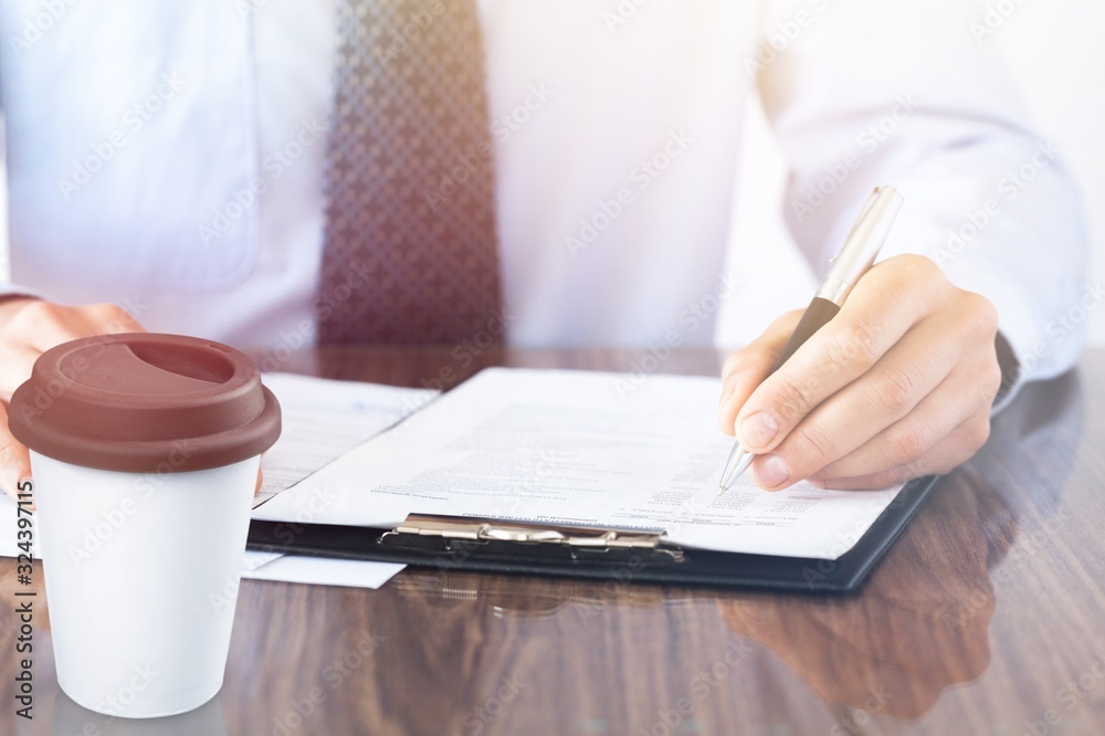 Businessman hands writing in a notebook on office desk