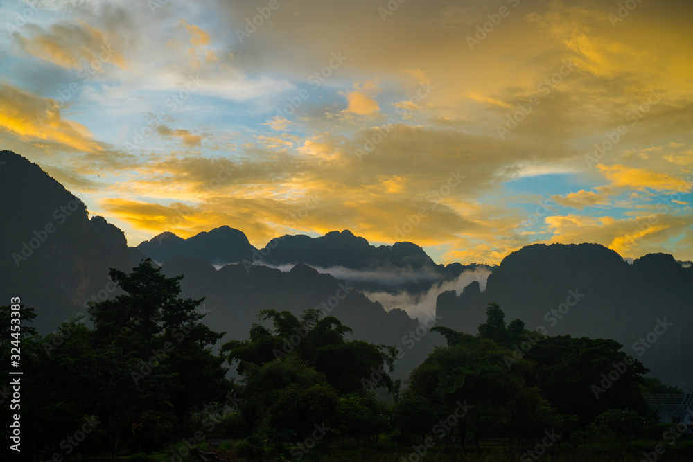 Silhouette of hills by the river at sunset. Stunning twilight sky at blue hours