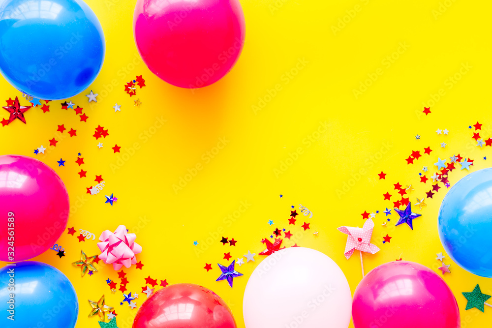 Party concept. Colorful balloons and confetti on yellow background top-down frame copy space