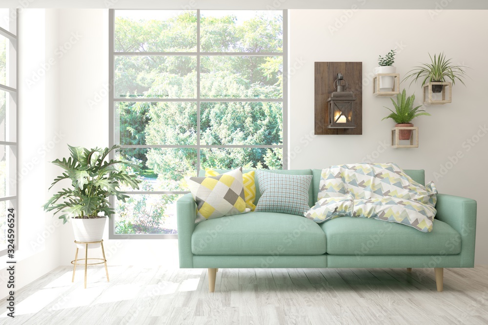 Minimalist living room in white color with sofa and summer landscape in window. Scandinavian interio