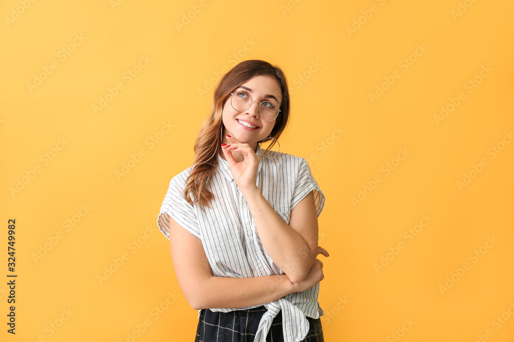 Thoughtful woman with stylish eyeglasses on color background